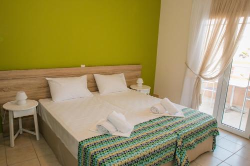 a bedroom with a bed with two towels on it at Sunny Beach Apartments in Rethymno Town