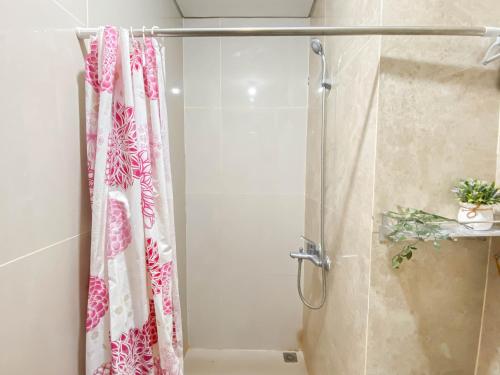 une douche avec un rideau de douche dans une salle de bain dans l'établissement Good Place and Spacious Studio Transpark Cibubur Apartment By Travelio, à Depok
