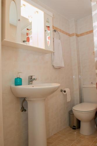 a bathroom with a sink and a toilet at Sunny Beach Apartments in Rethymno Town