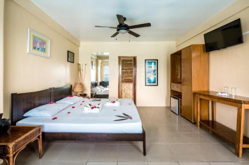 a bedroom with a bed and a flat screen tv at Campbells Beach Resort in Puerto Galera