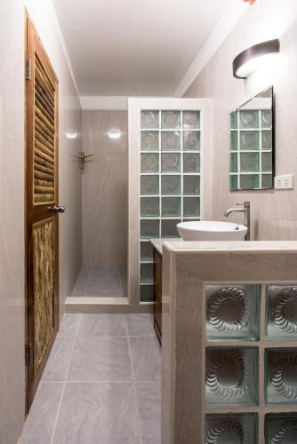 a bathroom with a sink and a shower at Campbells Beach Resort in Puerto Galera