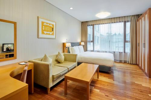 a hotel room with a bed and a couch at Somerset Palace Seoul in Seoul