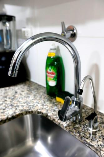 a bottle of green dish detergent sitting next to a sink at Perfect Balance Rest and Work Study Oceanfront in San Antonio