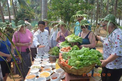 a group of people standing around a table with vegetables at Eskala Hotels and Resorts in Ngwesaung