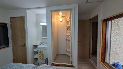 baño pequeño con lavabo y armario en Ippaku 一泊, en Izumisano