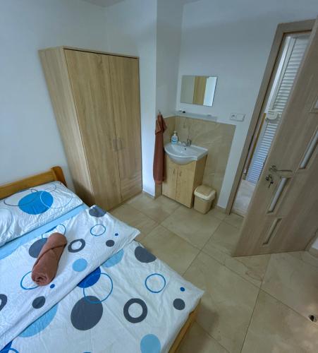 a bedroom with a bed and a bathroom with a sink at Chata U dědka in Prostřední Bečva