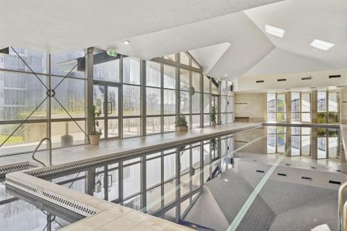 an empty lobby with windows and a pool at Gorgeous 2-Bed Unit near Riverside Parks in Sydney