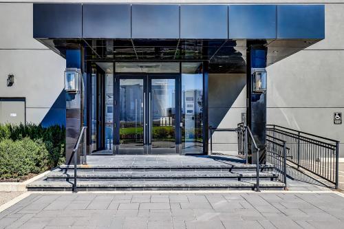 an entrance to a building with stairs and glass doors at Dream Suites Near YYZ Airport in Mississauga