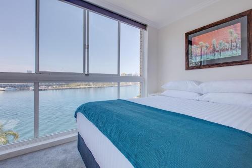 a bedroom with a bed and a large window at Wake up to Sydney Harbour in Sydney
