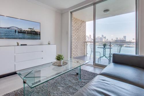 a living room with a couch and a glass table at Wake up to Sydney Harbour in Sydney