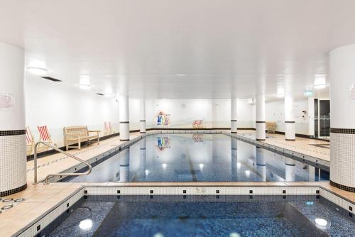 a large swimming pool in a building at Poolside 2-Bed Haven, Walk to City Centre in Sydney