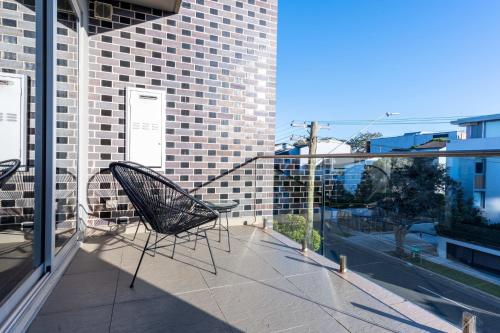 a pair of chairs sitting on a balcony at Comfy 1-Bed Apartment in Perfect Location in Sydney