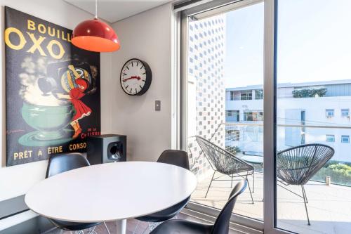 a dining room with a table and chairs and a clock at Comfy 1-Bed Apartment in Perfect Location in Sydney