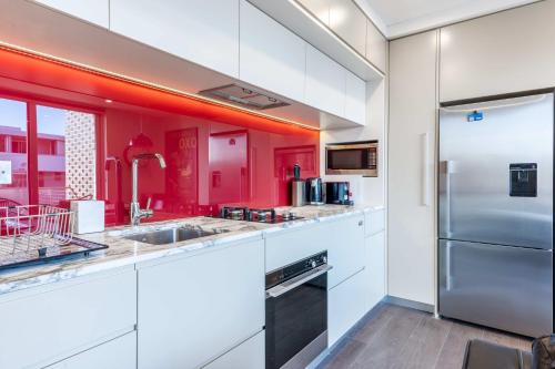 a kitchen with white cabinets and red walls at Comfy 1-Bed Apartment in Perfect Location in Sydney
