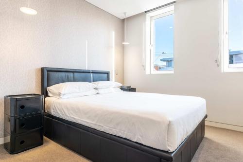 a bedroom with a large bed and a window at Comfy 1-Bed Apartment in Perfect Location in Sydney