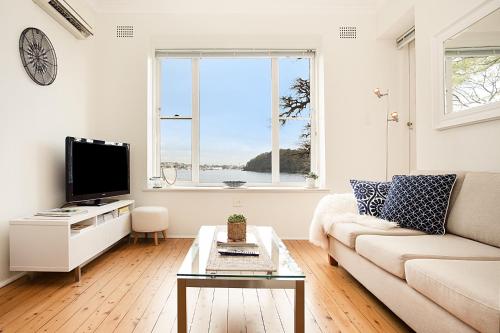 a living room with a couch and a tv at Harbourside - Unforgettable Destination in Sydney