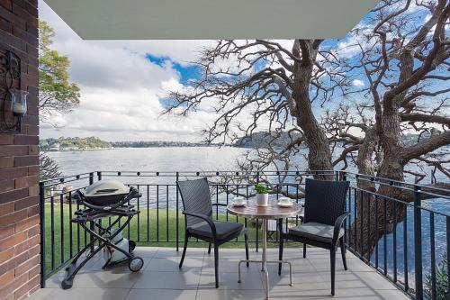 a patio with a table and chairs and a grill at Harbourside - Unforgettable Destination in Sydney