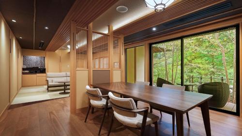 a dining room with a wooden table and chairs at 鹿覗きの湯つるや in Nakanojo