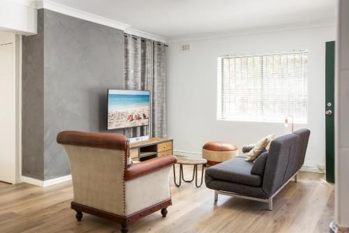 a living room with a couch and a chair at Suburban Two-bed Apartment with Parking and Patio in Sydney