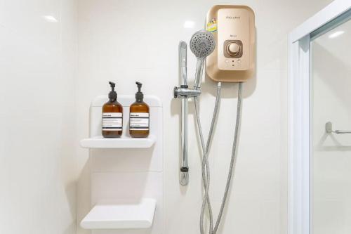 a bathroom with a shower with a hair dryer at 芭提雅市中心度假公寓 The Base预定 免费游泳池健身房 生活购物便利 in Pattaya Central
