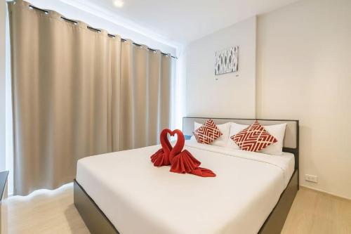 a bedroom with a bed with a red ribbon on it at 芭提雅市中心度假公寓 The Base预定 免费游泳池健身房 生活购物便利 in Pattaya Central
