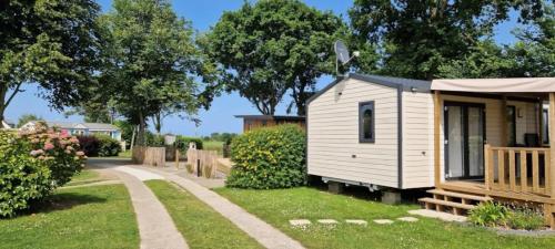a small white cabin in a yard with a path at ZEcamping 3 étoiles animaux acceptés à proximité des plus beaux sites in Pordic