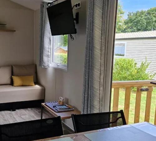 un salon avec un canapé et un balcon dans l'établissement Camping 3 étoiles - ccbc0hb, à Pordic