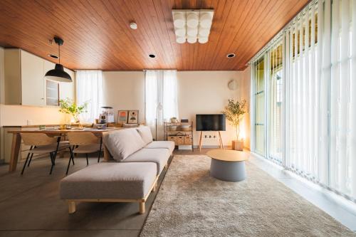 a living room with a couch and a table at Jomo Stay Takasaki 2 -the Garden- in Takasaki