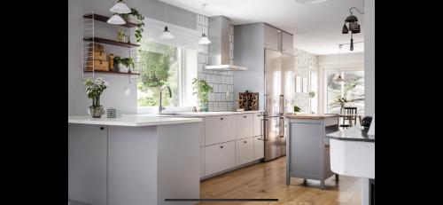 a kitchen with white cabinets and a large window at Beautiful house close to center in Gothenburg
