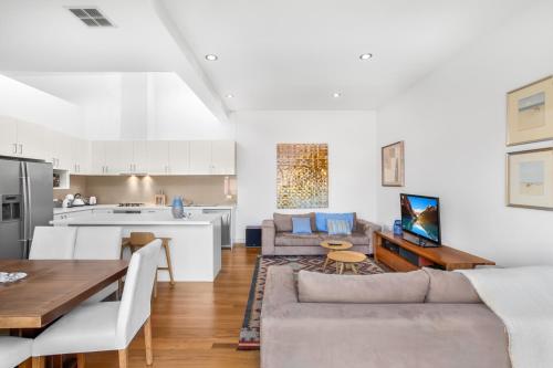 a living room with a couch and a table at 2-Bed Apartment with Parking & Balcony Near Trains in Yarraville