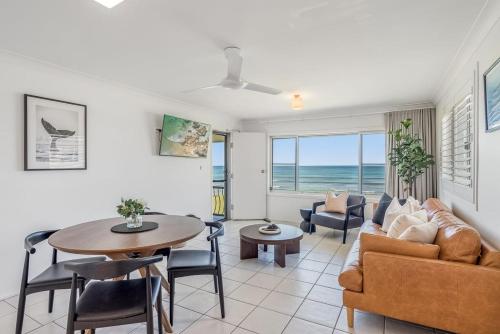 Absolute Beachfront Apartments 3T في لينوكس هيد: غرفة معيشة بها أريكة وطاولة