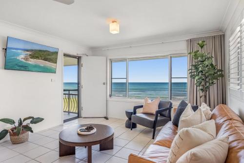 a living room with a couch and a table at Absolute Beachfront Apartments 3T in Lennox Head