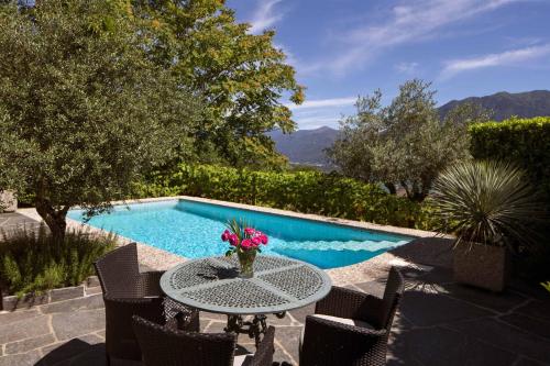 a table with flowers on it next to a swimming pool at Boutique Hotel Albergo Brione in Locarno