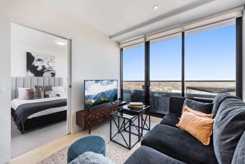 a living room with a couch and a bed at Chic 1-Bed with City Views Parking Gym & Pool in Melbourne