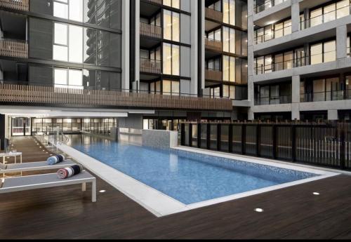 a large building with a swimming pool in front of it at Chic 1-Bed with City Views Parking Gym & Pool in Melbourne