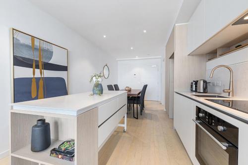 a kitchen with a counter and a dining room at Chic 1-Bed with City Views Parking Gym & Pool in Melbourne