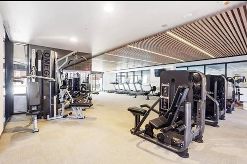 a gym with several treadmills and machines in it at Chic 1-Bed with City Views Parking Gym & Pool in Melbourne