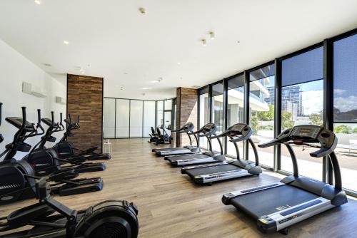 a gym with a row of treadmills at Modern 1-Bed Apartment With Parking, Pool and Gym in Phillip