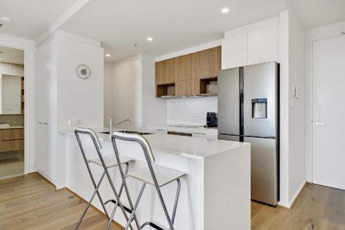a kitchen with white counters and a refrigerator at Modern 1-Bed Apartment With Parking, Pool and Gym in Phillip