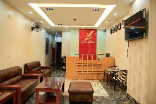 ein Wartezimmer mit einem TV, einem Sofa und einem Tisch in der Unterkunft Jeanne Hotel in Cao Bằng