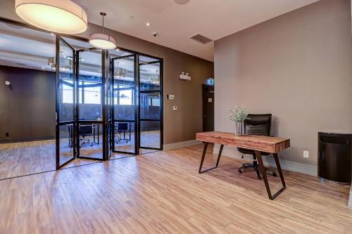 an empty office with a wooden table and chairs at Dream Suites Near YYZ Airport in Mississauga