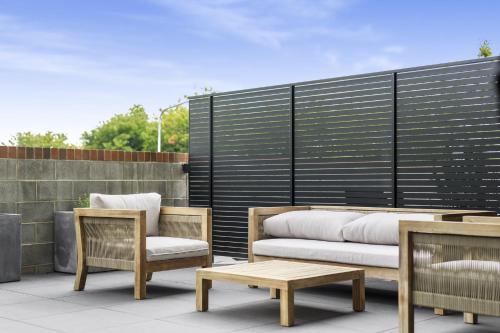 un patio avec des chaises, un canapé et une table dans l'établissement Boutique Unit with Huge Terrace near Cafes & Shops, à Kingston 