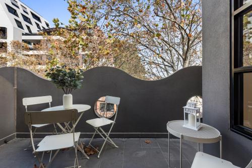 a patio with two tables and chairs and a window at Beautiful 2-Storey Unit with Balcony near Smith St in Melbourne
