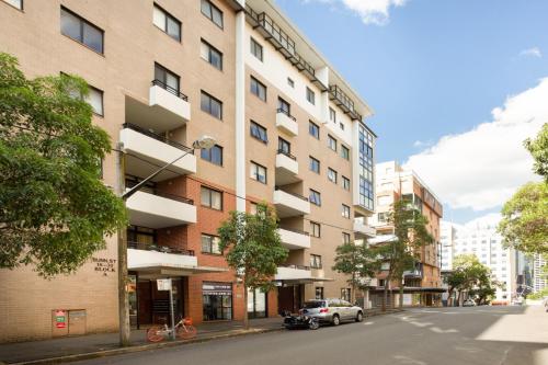 a building on a street with a car parked in front at Chic Unit with Rooftop Terrace near Sights & Shops in Sydney