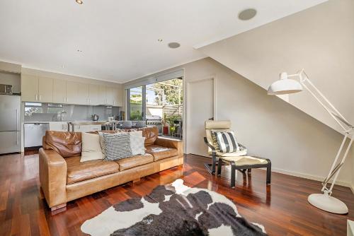a living room with a couch and a kitchen at Stunning 2-Bed Unit with BBQ Patio near Dining in Melbourne
