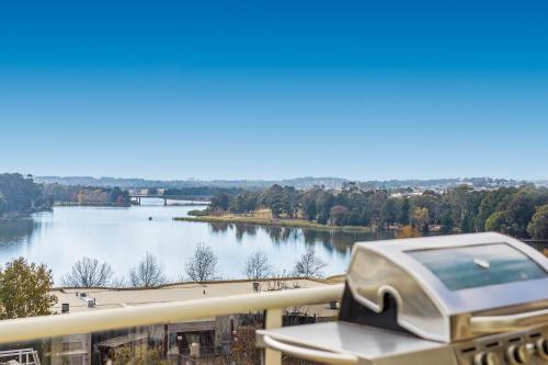avr on a balcony with a view of a river at 2-Bed Unit with Balcony BBQ & Stunning Lake Views in Belconnen
