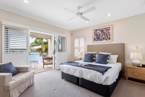 a bedroom with a large bed and a couch at Amazing Canal House with Private Jetty, Gym & Pool in Mooloolaba