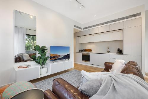 a living room with a couch and a kitchen at Bright Terrace Unit Next to Chapel St Dining in Melbourne