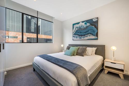 a bedroom with a bed and a large window at Bright Terrace Unit Next to Chapel St Dining in Melbourne