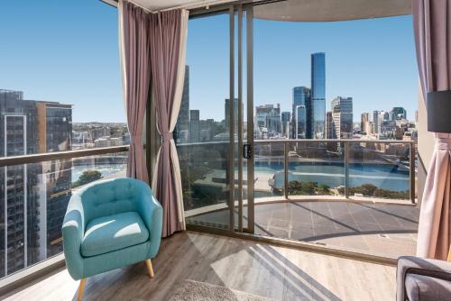 a room with a blue chair and a large window at River-View Unit with Rooftop Pool near Museums in Brisbane